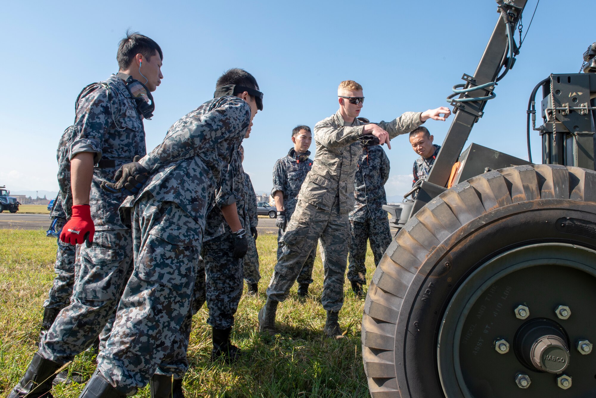 Airman 1st Class Cameron Connelly, 374th Civil Engineer Squadron electrical power production, provides instructions to Koku Jietai (Japan Air Self-Defense Force) service members prior to installing the Mobile Aircraft Arresting System (MAAS) at a bilateral training event at Yokota Air Base, Japan, Oct. 25, 2018.