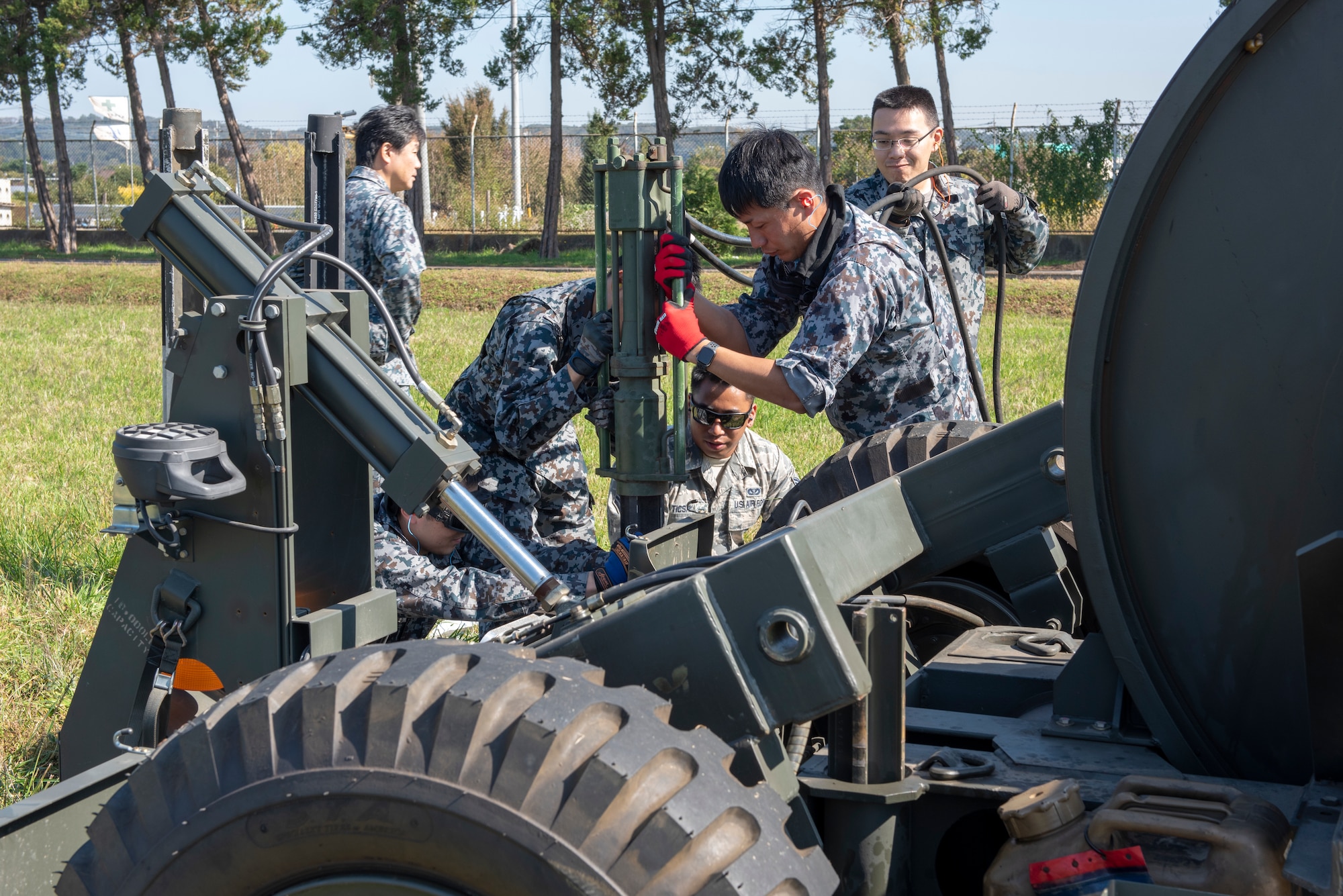 Airmen from the 374th Civil Engineer Squadron work with Koku Jietai (Japan Air Self-Defense Force) members to secure the Mobile Aircraft Arresting System (MAAS) in place at a bilateral training event at Yokota Air Base, Japan, Oct. 25, 2018.