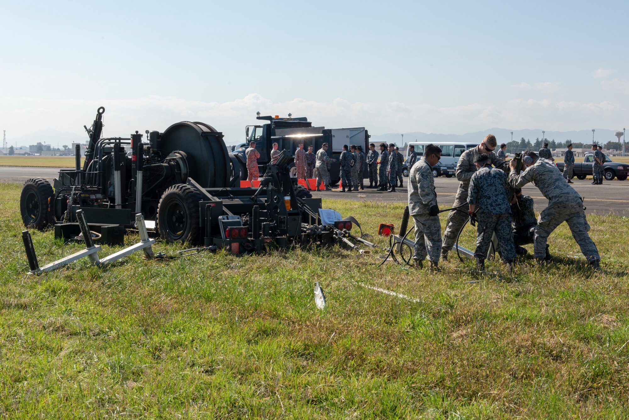 Airmen from the 374th Civil Engineer Squadron work with Koku Jietai (Japan Air Self-Defense Force) members to secure the Mobile Aircraft Arresting System (MAAS) in place at a bilateral training event at Yokota Air Base, Japan, Oct. 25, 2018.