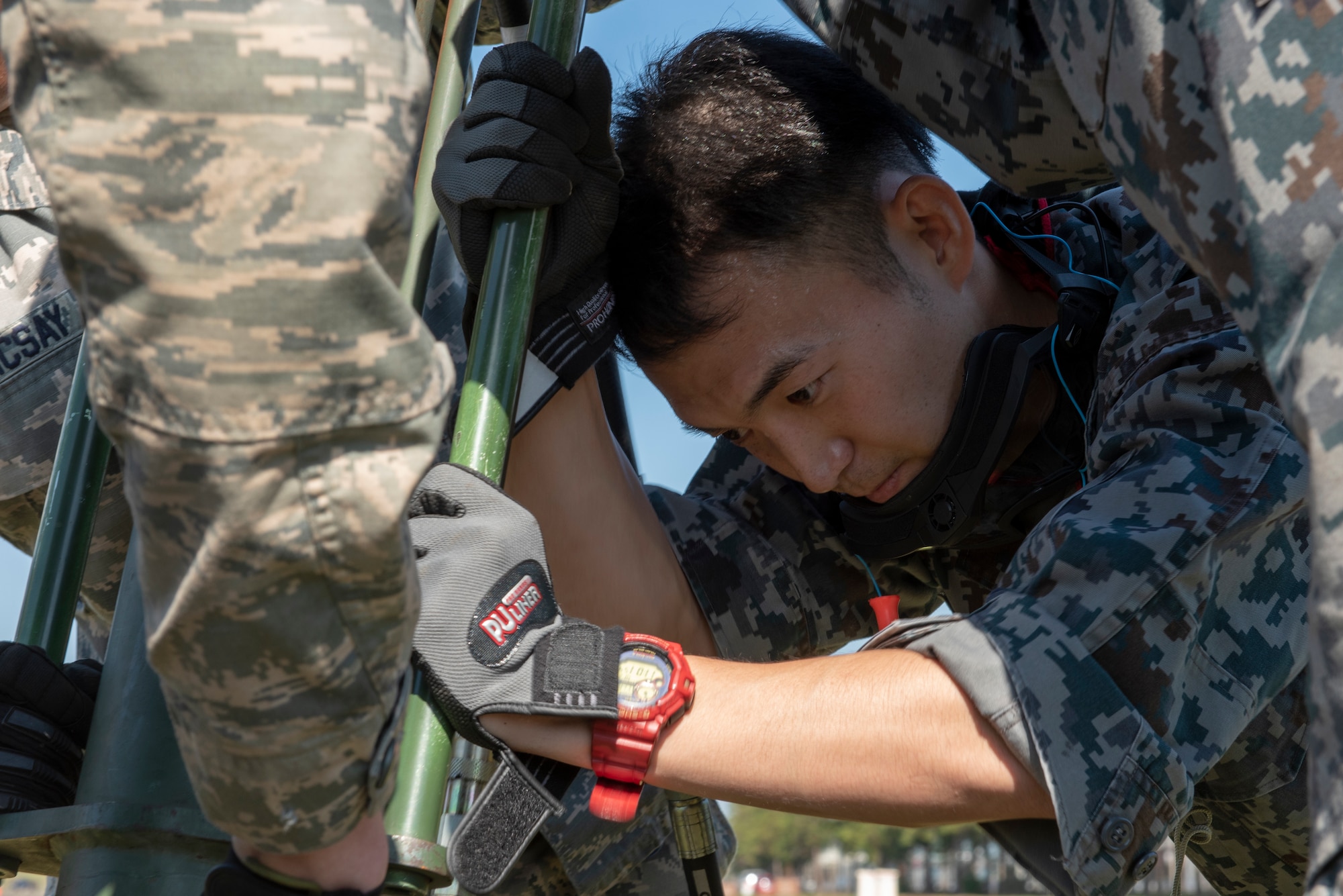 A member of the Koku Jietai (Japan Air Self-Defense Force) works with the Airmen from the 374th Civil Engineer Squadron to secure the Mobile Aircraft Arresting System (MAAS) in place at a bilateral training event at Yokota Air Base, Japan, Oct. 25, 2018.