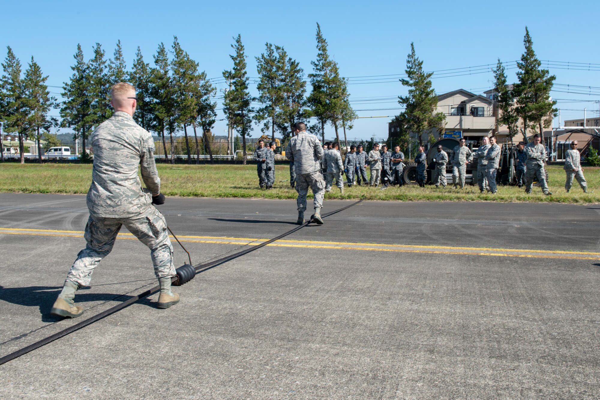 Airmen from the 374th Civil Engineer Squadron work to properly spread out the donuts on the line of a Mobile Aircraft Arresting System (MAAS) at a bilateral training event at Yokota Air Base, Japan, Oct. 25, 2018.