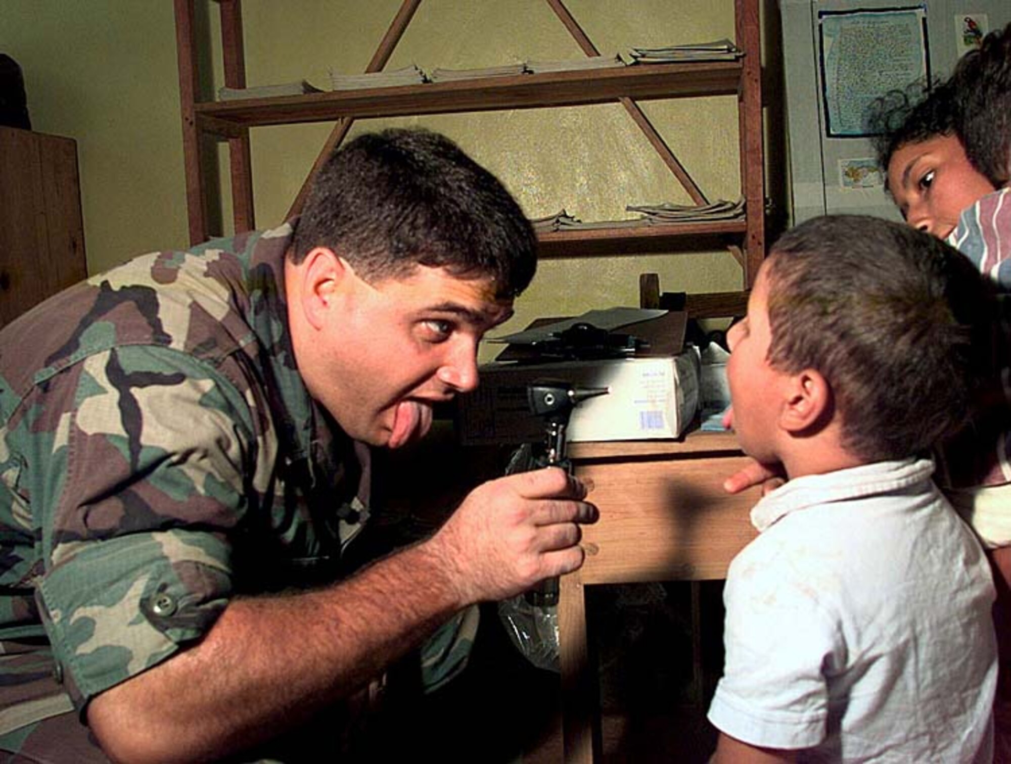 U.S. Air Force Capt. (Dr.) Cody Henderson, a pediatrician assigned to a 24th Medical Group Medical Readiness Training Exercise Team, examines a boy in a temporary field hospital in the Honduran village of Campo II, November 1998. U.S. joint-service medical teams drove into the Honduran countryside daily to treat people effected by Hurricane Mitch. (U.S. Army photo by Spc. Jeremy Ausburn)
