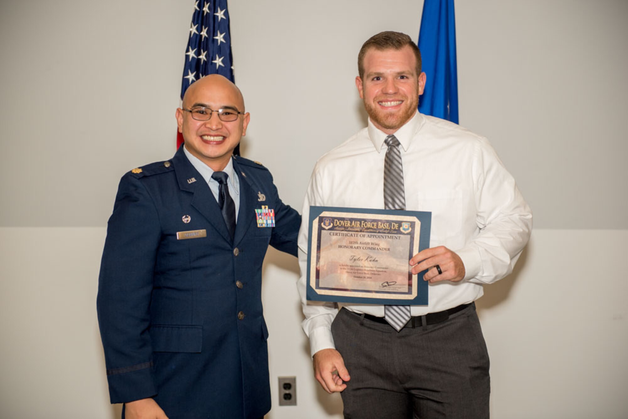 Maj. Alfred Ocampo, 512th Logistics Readiness Squadron commander, presents an honorary commander certificate to Tyler Kuhn, honorary commander inductee for the 512th LRS during the Honorary Commander Induction ceremony at Dover Air Force Base, Delaware, Oct. 20, 2018. Kuhn is the marketing director for Dover Federal Credit Union. (U.S. Air Force photo by Staff Sgt. Damien Taylor)