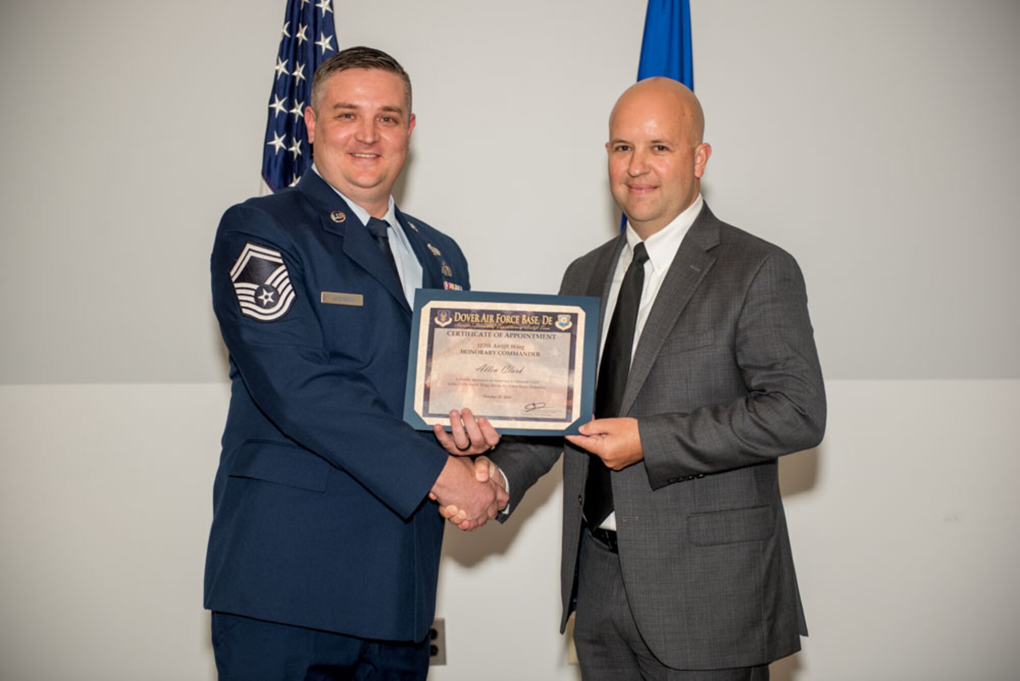 Senior Master Sgt. David Jackson, 512th Logistics Readiness Squadron superintendent, presents an honorary commander certificate to Allen Clark, honorary commander inductee assigned to the  512th Airlift Wing command chief during the Honorary Commander Induction ceremony at Dover Air Force Base, Delaware, Oct. 20, 2018. Clark is the senior manager, business administration at Dover Motorsports. (U.S. Air Force photo by Staff Sgt. Damien Taylor)