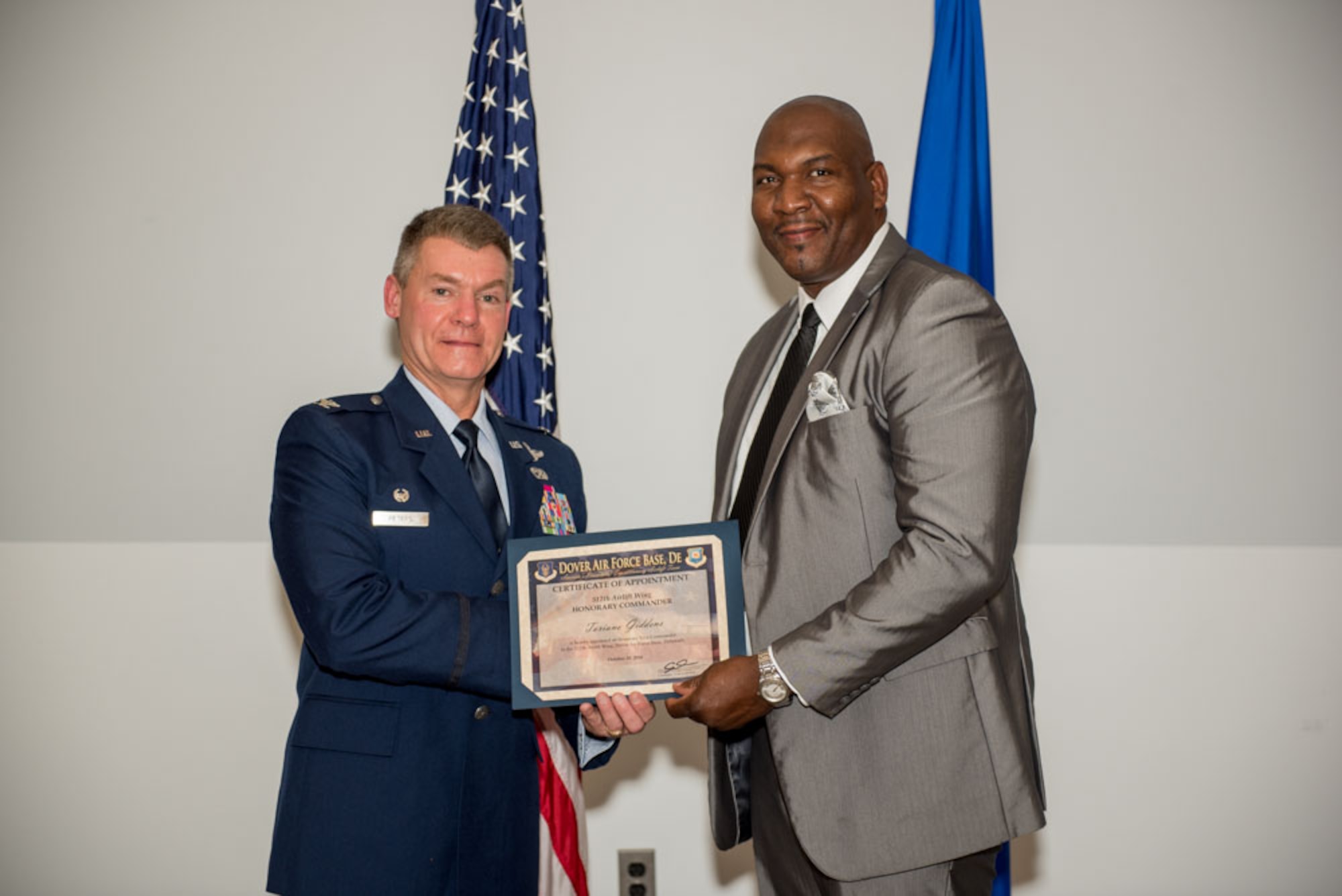 Col. Craig Peters, 512th Airlift Wing commander, presents an honorary commander certificate to Toriano Giddens, honorary commander inductee assigned to the 512th AW vice commander during the Honorary Commander Induction ceremony at Dover Air Force Base, Delaware, Oct. 20, 2018. Giddens is the principle a Towne Point Elementary School. (U.S. Air Force photo by Staff Sgt. Damien Taylor)