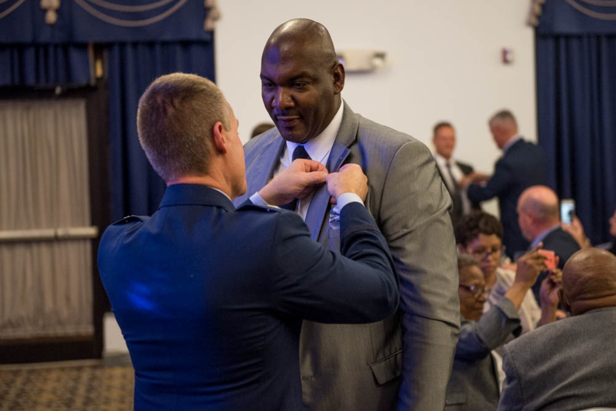 Col. Craig Peters, 512th Airlift Wing commander, tacks a commander insignia badge on Torriano Giddens, honorary commander assigned to the 512th AW vice commander, during the Honorary Commander Induction ceremony at Dover Air Force Base, Delaware, Oct. 20, 2018. Honorary commander inductees received badges symbolizing their partnership with the base and military leaders. (U.S. Air Force photo by Staff Sgt. Damien Taylor)