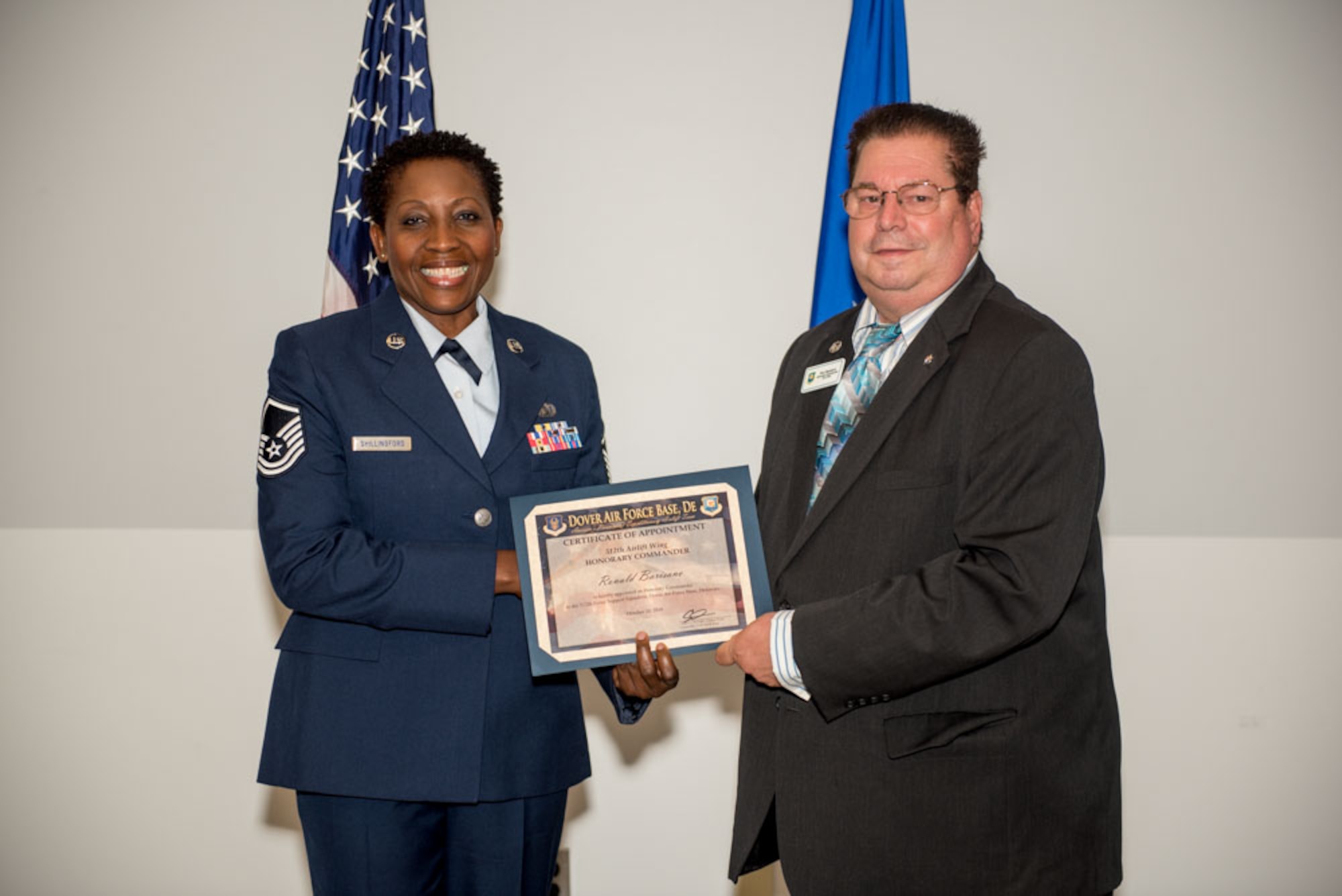 Master Sgt. Marina Shillingford, 512th Airlift Wing chief of career development, presents an honorary commander certificate to Ronald Barisano, returning Force Support Squadron honorary commander during the Honorary Commander Induction ceremony at Dover Air Force Base, Delaware, Oct. 20, 2018. Barisano is the admissions director at St. John’s Lutheran School. (U.S. Air Force photo by Staff Sgt. Damien Taylor)