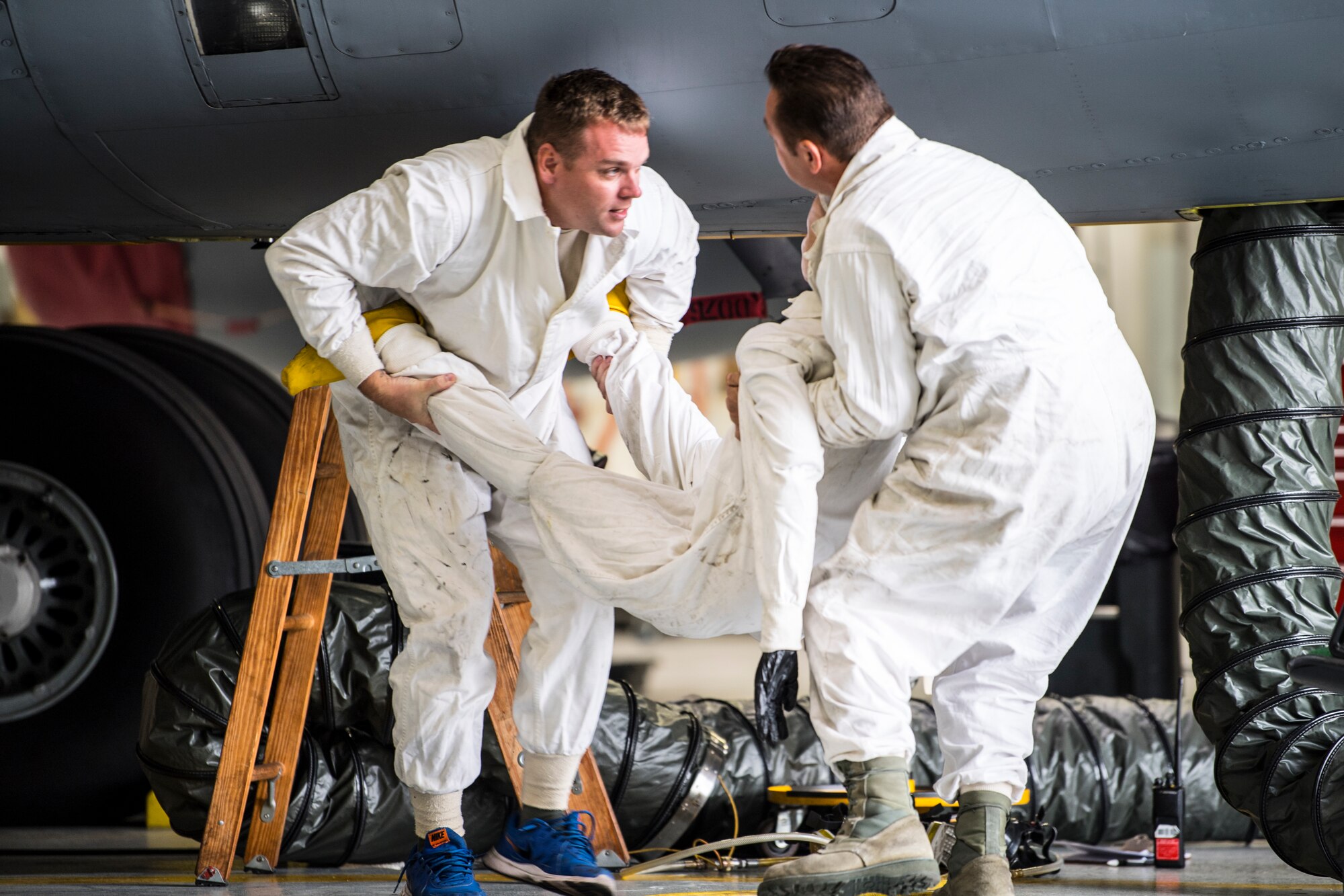 Staff Sgt. Kevin Davin and Tech Sgt. Chris Mollison, 434th Maintenance Squadron fuels system technicians, carry a training dummy after having extracted it from the fuel tank of a KC-135R Stratotanker at Grissom Air Reserve Base, Ind., Oct. 4, 2018. Fuels system technicians are required to practice emergency responses in the event that an Airman becomes injured or incapacitated while inside an aircraft. (U.S. Air Force photo / Senior Airman Harrison Withrow)