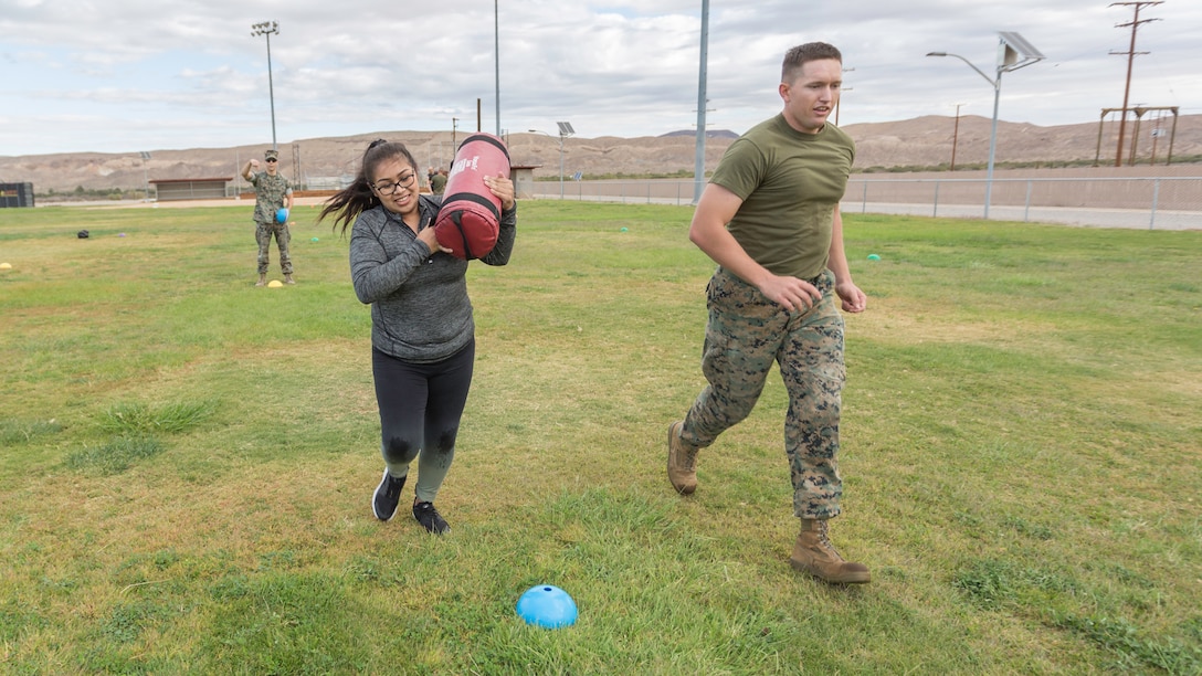 Sgt. Benjamin Crouch, Supply Administrator, runs with his wife, Blanca Crouch, during the Combat Fitness Test event during Jane Wayne Day aboard Marine Corps Logistics Base Barstow, Calif., Oct. 12. 
(U.S. Marine Corps Photo by Jack J. Adamyk)