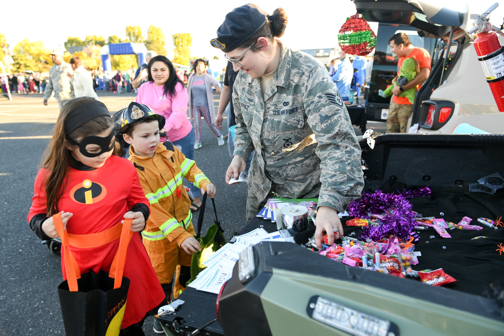 Staff Sgt. Cathleen Gutierrez, 75th Security Forces, hands Halloween treats to Mia and Quinn Valenciano during the Haunting on the Hill celebration Oct. 19, 2018 at Hill Air Force Base, Utah. (U.S. Air Force photo by Cynthia Griggs)