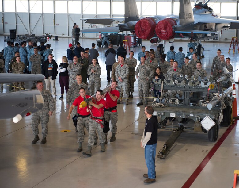 Image of Members of the 389th Fighter Squadron lift a munition to take to their jet during a weapons loading competition, Oct. 18, 2018, at Mountain Home Air Force Base, Idaho. The purpose of the competition is to simulate pressures of a deployed environment and instill pride and morale. (U.S. Air Force photo by Senior Airman Alaysia Berry)