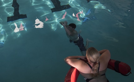 U.S. Navy Machinist Mate 2nd Class Andrew Kessler, Harbor Patrol Unit, performs the burning oil maneuver during the first-class swim qualification test Oct. 19, 2018, at the Danny Jones Recreational Center, North Charleston, S.C.