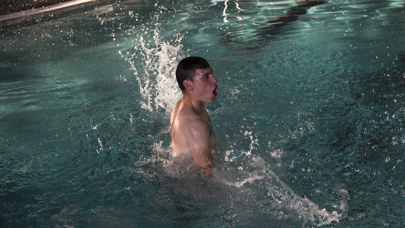 U.S. Navy Machinist Mate 2nd Class Andrew Kessler, Harbor Patrol Unit, performs the burning oil maneuver during the first-class swim qualification test Oct. 19, 2018, at the Danny Jones Recreational Center, North Charleston, S.C.