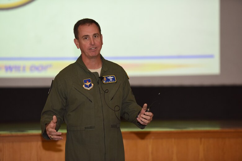 a man talks in front of a stage