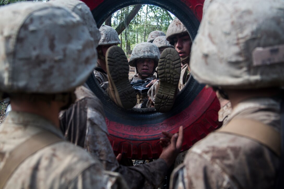 Recruits with Mike Company, 3rd Recruit Training Battalion, put a recruit through a tire during the Crucible on Marine Corps Recruit Depot Parris Island, S.C., Oct. 18, 2018. The Crucible is a 54-hour culminating event that requires recruits to work as a team and overcome challenges in order to earn the title United States Marine. (U.S. Marine Corps photo by Lance Cpl. Andrew Neumann)