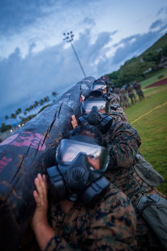 U.S. Marines with Headquarters Battalion, Marine Corps Base Hawaii (MCBH), participate in log lifts during a circuit course training event with their M53 gas masks, MCBH, Oct. 19, 2018. The circuit course and experience consisted of various workouts while the Marines wore their gas masks, providing confidence and experience with the equipment while remaining highly active in a simulated Chemical, Biological, Radiological, Nuclear Defense environment. (U.S. Marine Corps photo by Cpl. Matthew Kirk)