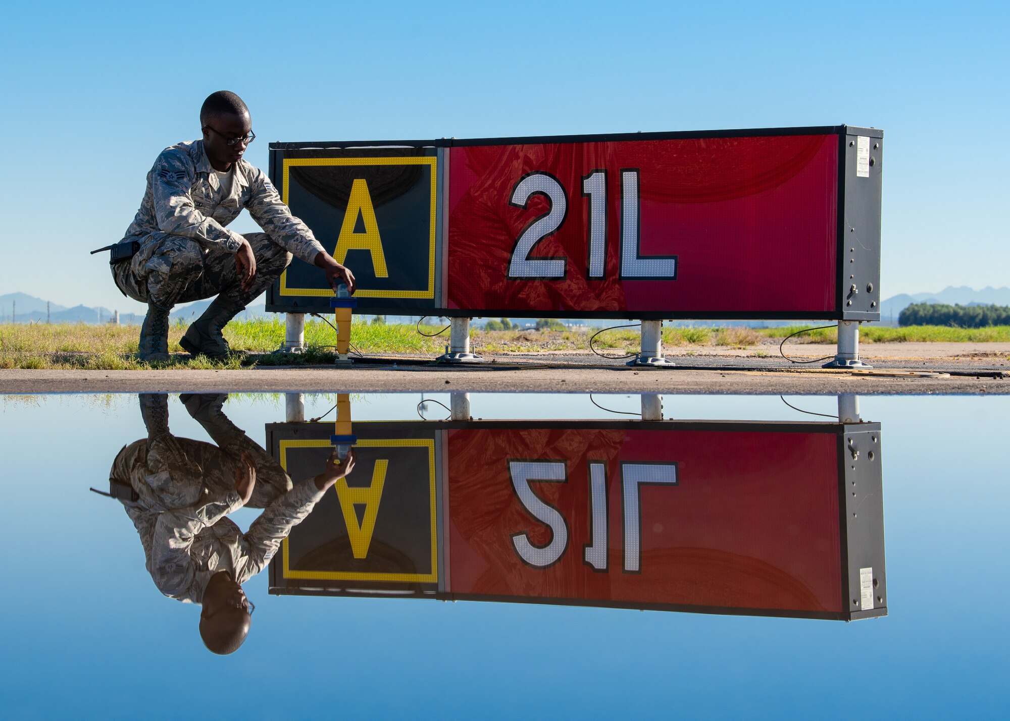 Senior Airman Derrick Beleski, 56th Operation Support Squadron airfield management operations supervisor, inspects a runway light, Oct. 24, 2018, at Luke Air Force Base, Ariz.