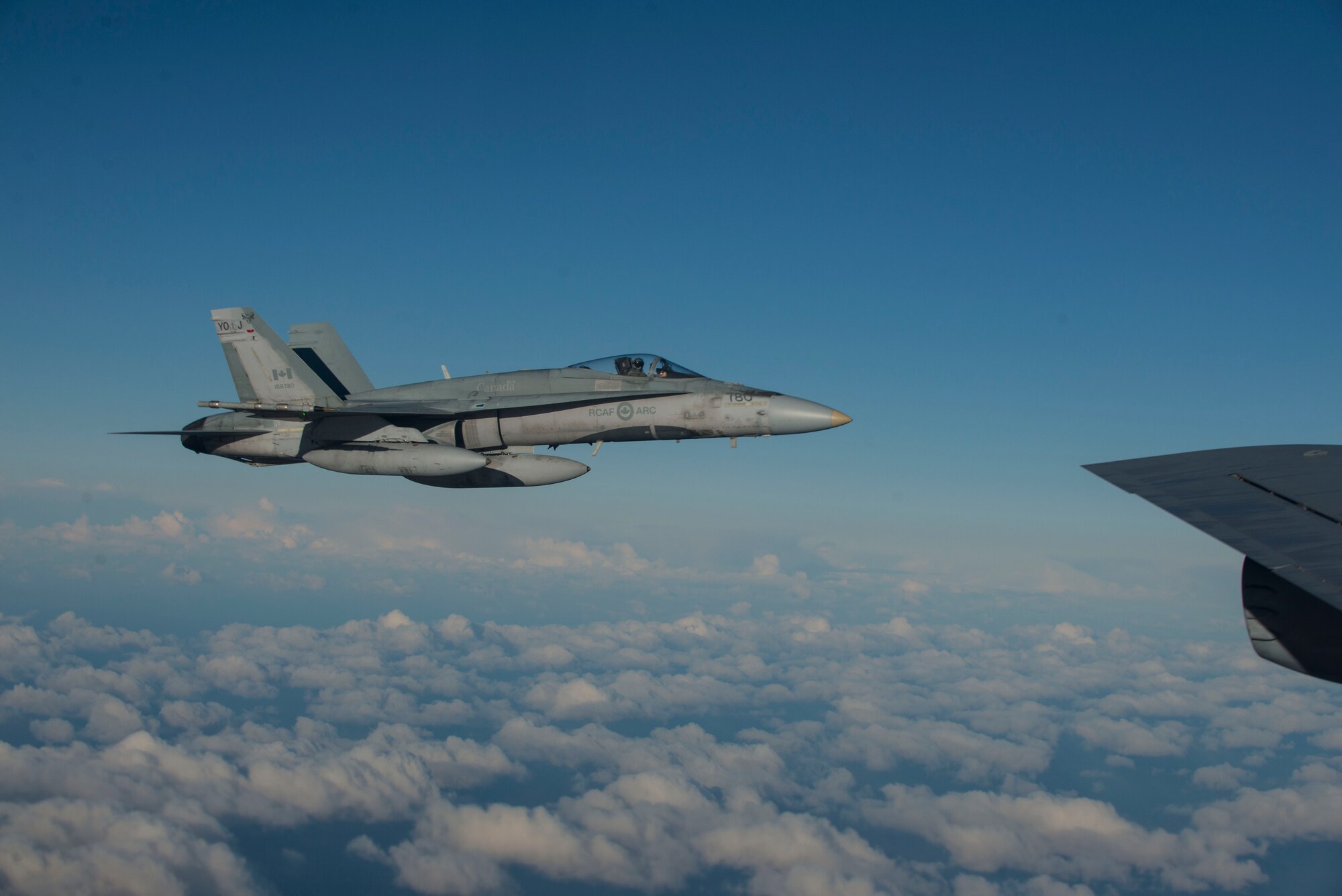 A Royal Canadian Air Force CF-188 Hornet flies alongside a U.S. Air Force KC-135 Stratotanker during Exercise Trident Juncture 18, off the coast of Norway, Oct. 27, 2018. Trident Juncture is the largest NATO exercise since 2015, with participation of more than 50,000 military members from 31 nations. The exercise provides U.S. forces with unique opportunities to train with NATO allies and partners. (U.S. Air Force photo by Senior Airman Luke Milano)