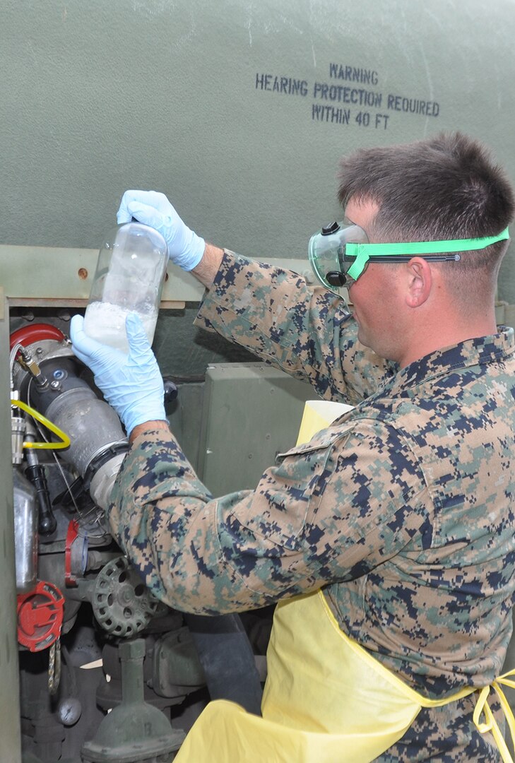 Marine Corps Sgt. Andrew Grable examines a sample of fuel before conducting laboratory testing to ensure it meets military specifications. The Marines tested a prototype Expeditionary Mobile Fuel Additization Capability during the Rim of the Pacific exercise.
