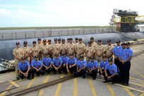 Crew members from the Peruvian submarine BAP Arica (SS-36) pose for group photos in front of the Ohio-class ballistic missile submarine USS Maryland