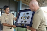 Capt. Robert Wirth, commodore of Submarine Squadron 20, presents Cmdr. Enrique Vargas, captain of Peruvian Submarine BAP Arica (SS-36), with a commemorative photo of the Kings Bay submarine fleet.
