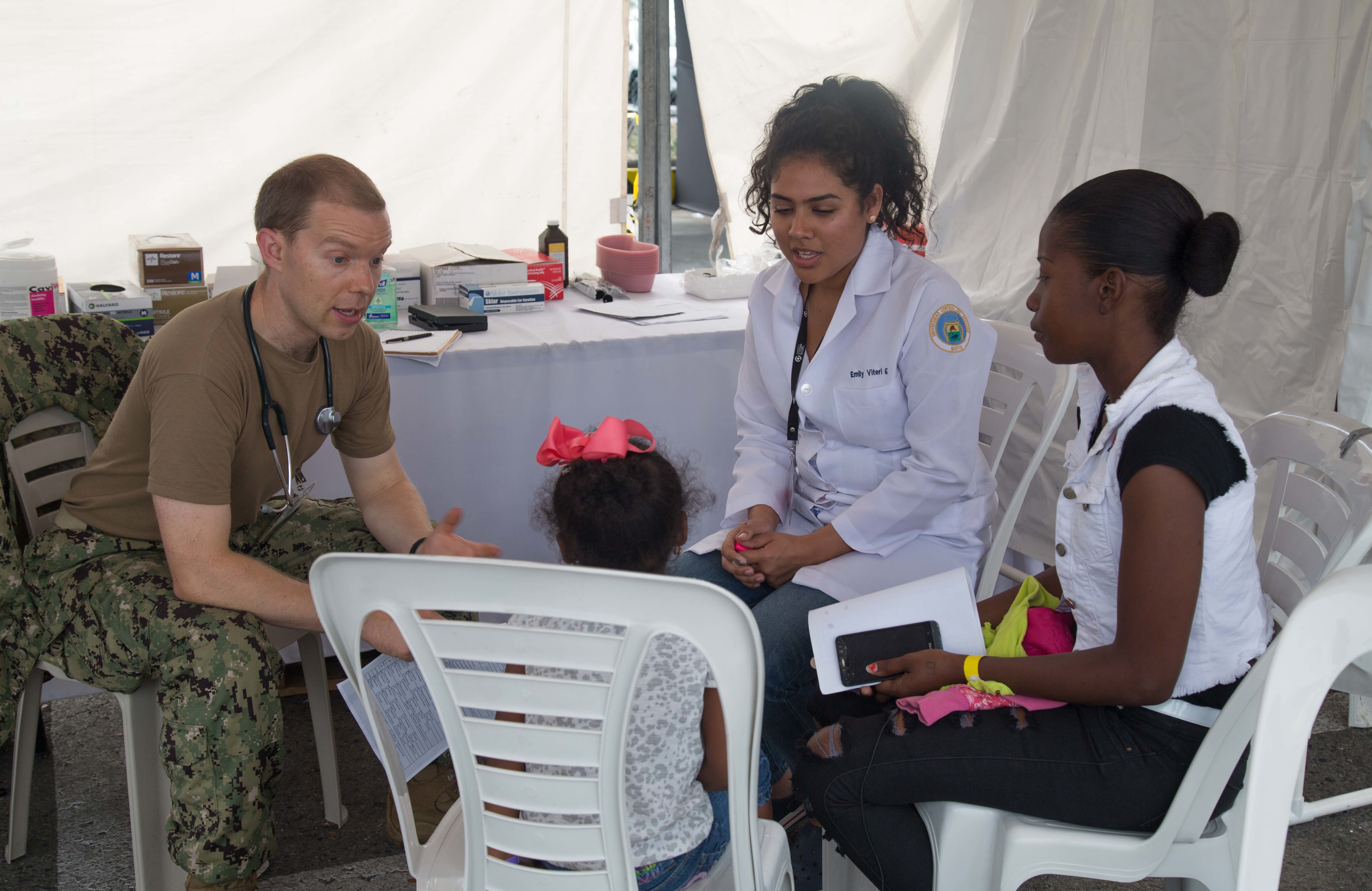 Lt. Andrew Winslow, a pediatrician, from Eden Prairie, Minn., and Emily Vilteri, a medical student enrolled at Central University of Ecuador from Milagro, Ecuador, talk with patients at one of two medical sites. The hospital ship USNS Comfort (T-AH 20) is on an 11-week medical support mission to Central and South America as part of U.S. Southern Command’s Enduring Promise initiative.