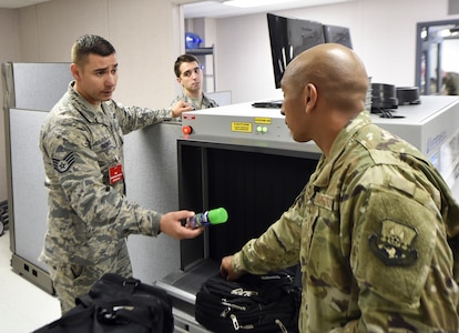 Staff Sgt. James Barker, 437th Aerial Port Squadron passenger operations supervisor, removes an unauthorized item from a bag at a security checkpoint Oct. 15, 2018.