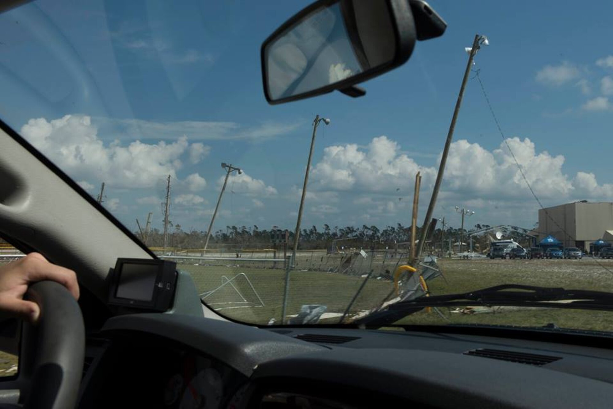 1st Lt. Adam Kriete, 337th Air Control Squadron student, drives pas a damaged baseball field Oct. 19, 2018, at Tyndall Air Force Base, Fla. In the aftermath of Hurricane Michael, the Krietes relied on the Air Force and each other to overcome adversity. (U.S. Air Force photo by Airman 1st Class Dalton Williams)