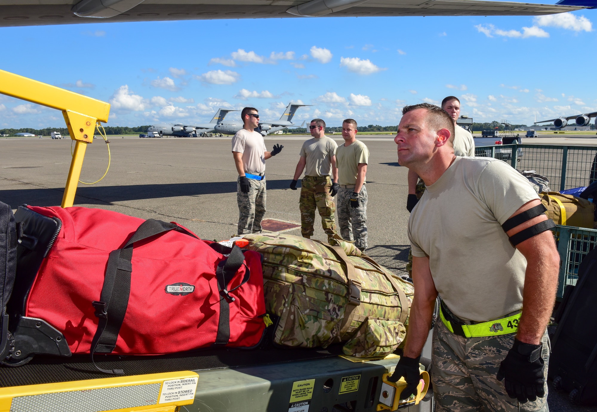 Airman 1st Class Ian Huffman, 437th Aerial Port Squadron passenger operations technician, moves baggage up a conveyer while loading luggage as part of a mission to deploy service members through Joint Base Charleston Oct. 15, 2018 in support of the Naval Station Norfolk air terminal while their airfield under goes scheduled maintenance.