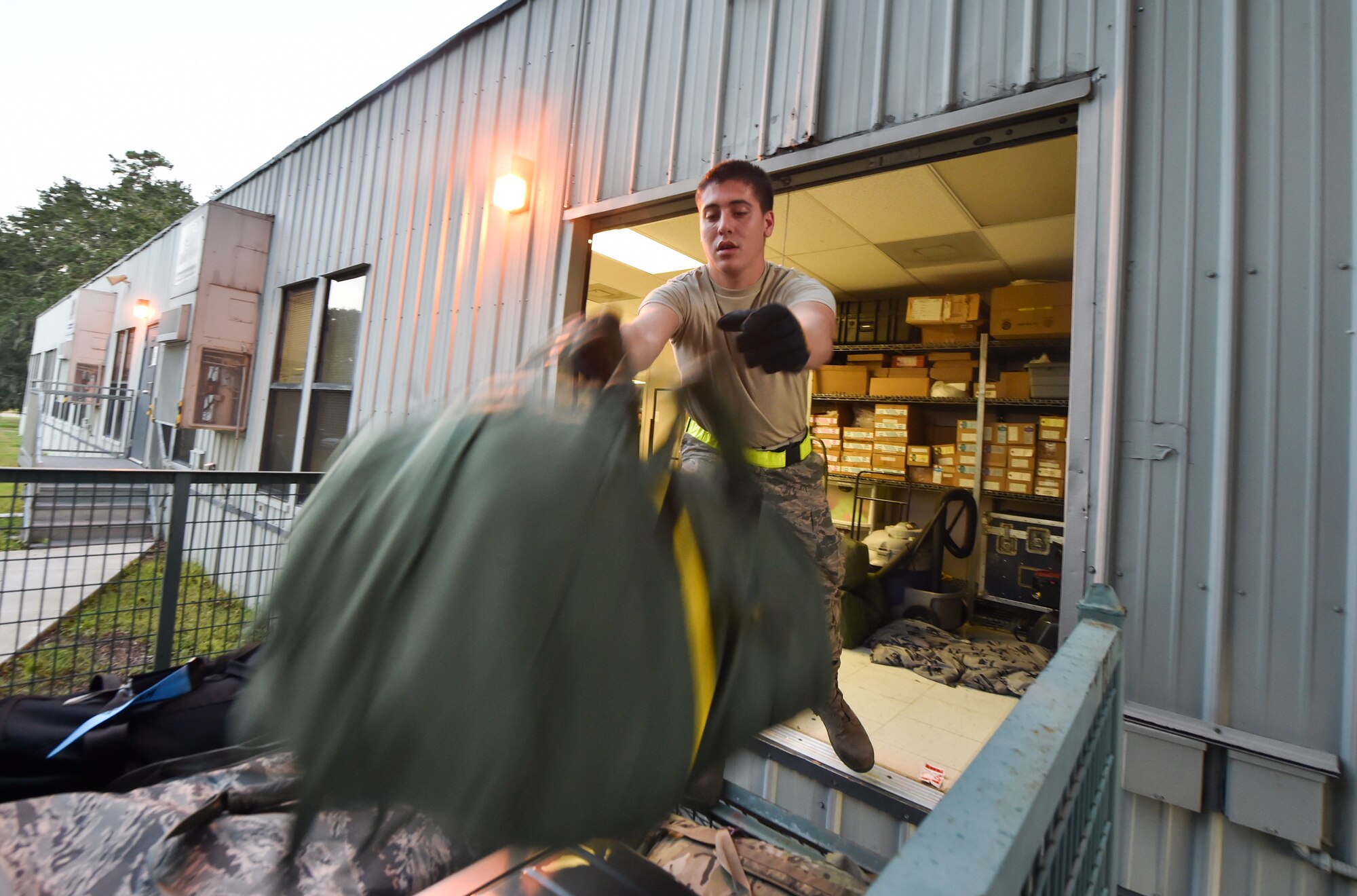 Airman 1st Class Brett Petraitis, 437th Aerial Port Squadron passenger operations technician, stacks bags into a container to be transported to the Joint Base Charleston flightline Oct. 15, 2018.