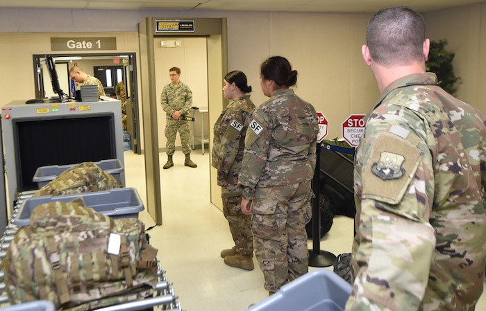 Passengers wait in line as they are processed through a checkpoint in the Joint Base Charleston Temporary Passenger Terminal during a deployment movement Oct. 15, 2018 in support of the Naval Station Norfolk air terminal while their airfield undergoes scheduled maintenance.