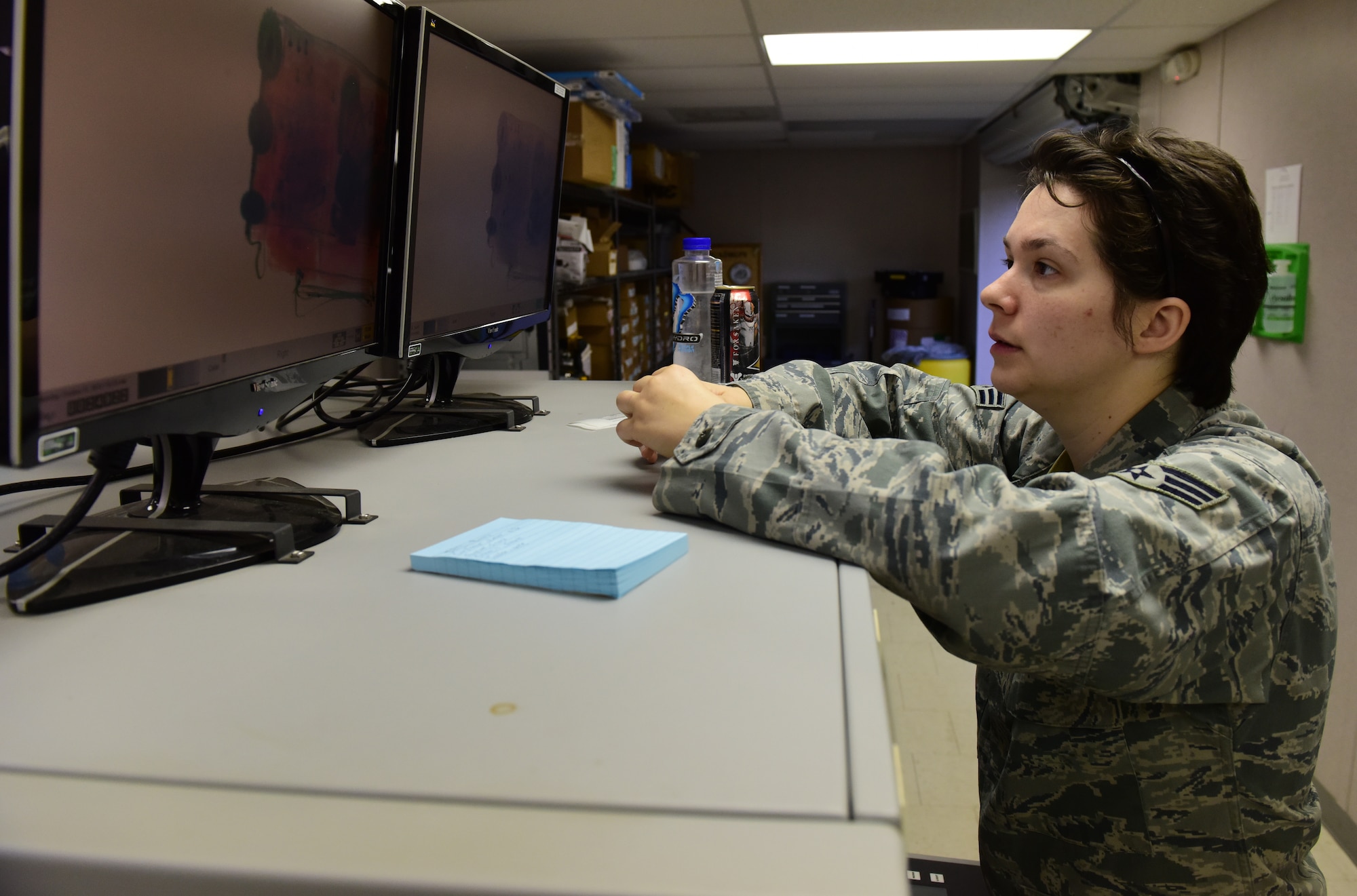 Senior Airman Vanessa Olinger, 437th Aerial Port Squadron passenger operations technician, scans bags as they move through an X-ray machine as part of a mission to deploy service members through Joint Base Charleston Oct. 15, 2018.