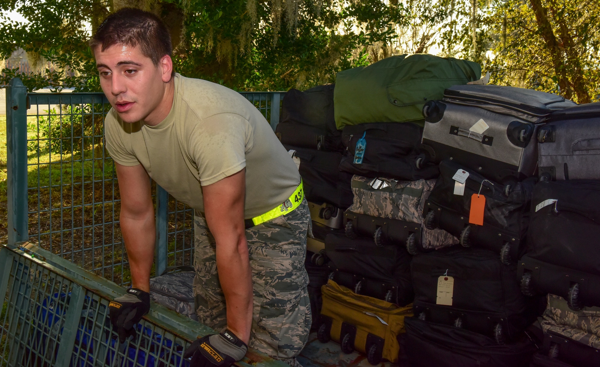 Airman 1st Class Brett Petraitis, 437th Aerial Port Squadron passenger operations technician, waits to be handed the next bag as he stacks them for transportation to the Joint Base Charleston flightline Oct. 15, 2018.