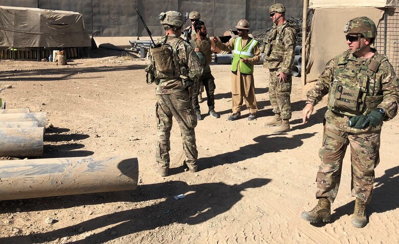 Project Engineer Brian Cagle, Kandahar Detachment,  discusses the progress of the Well tests with the Local National Quality Assurance Representatives while Deputy Commanding Officer, Michael Harding, Afghanistan  District looks onward to the Well Site.