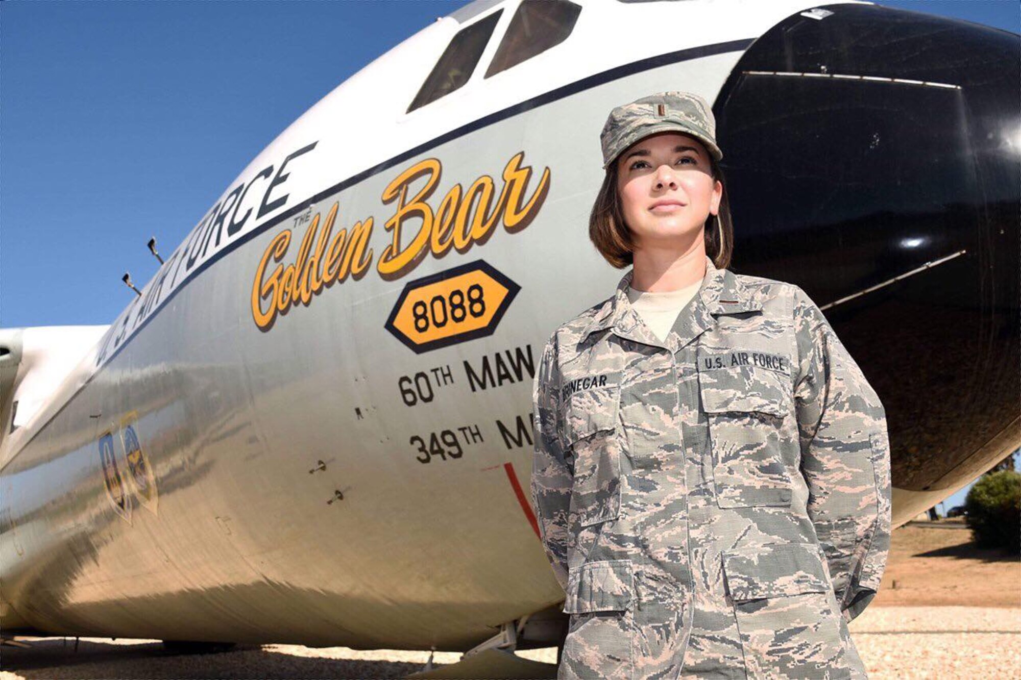 2nd Lt. Rachel Brinegar, 60th Air Mobility Wing public affairs officer, poses in front of a C-141 Starlifter, "Golden Bear," a Travis Air Force Base, Calif., landmark Oct. 25. Brinegar's first assignment as an officer is at Travis, where reconciling the roles of supervisor and executive has required, she said, "a big change in mindset."