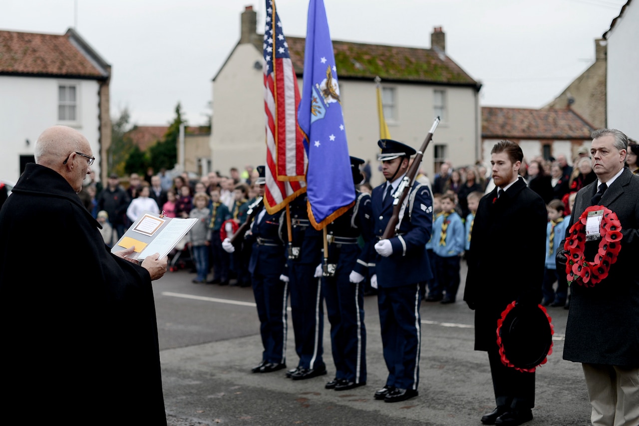 Color guard and officials stand with wreaths.