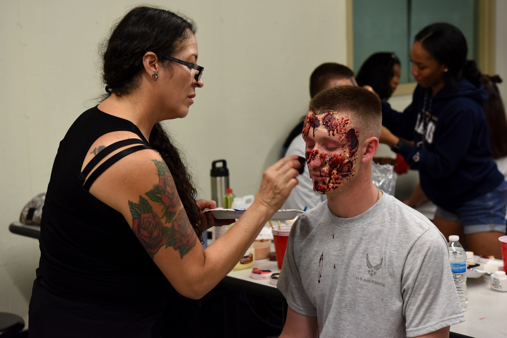 U.S. Air Force Airman Cody Jarrad, 312th Training Squadron student, receives makeup to look like a zombie for Ghoulfellow in the Louis F. Garland Department of Defense Fire Academy on Goodfellow Air Force Base, Texas, Oct. 27, 2018. Jarrad was a zombie in the Zombie Run, where volunteers chased runners and stole their flags along the trail. (U.S. Air Force photo by Airman 1st Class Zachary Chapman/Released)