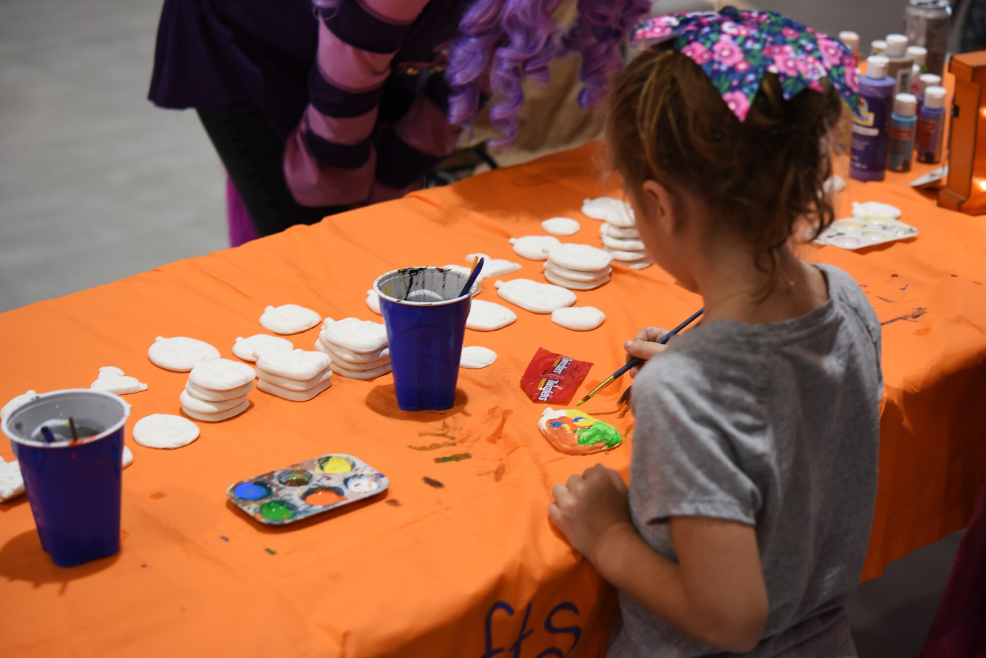 A child paints a ceramic pumpkin during the kid’s carnival at Ghoulfellow in the Louis F. Garland Department of Defense Fire Academy on Goodfellow Air Force Base, Texas, Oct. 27, 2018. Booths were set up in the High Bay with carnival games for children to play. (U.S. Air Force photo by Airman 1st Class Zachary Chapman/Released)