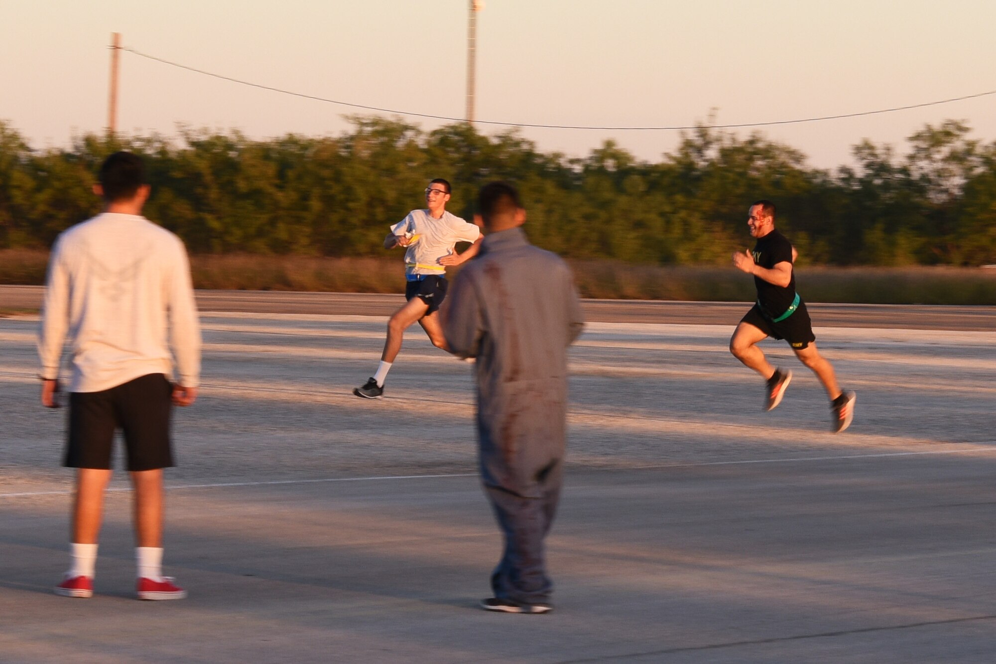 U.S. Air Force Airman Joseph Detrano, 315th Training Squadron student, runs past a group of zombies for the Zombie Run during Ghoulfellow at the Louis F. Garland Department of Defense Fire Academy on Goodfellow Air Force Base, Texas, Oct. 27, 2018. The Zombie Run challenged competitors to make their way around the course while dodging zombies who would try to steal their flags. (U.S. Air Force photo by Airman 1st Class Zachary Chapman/Released)