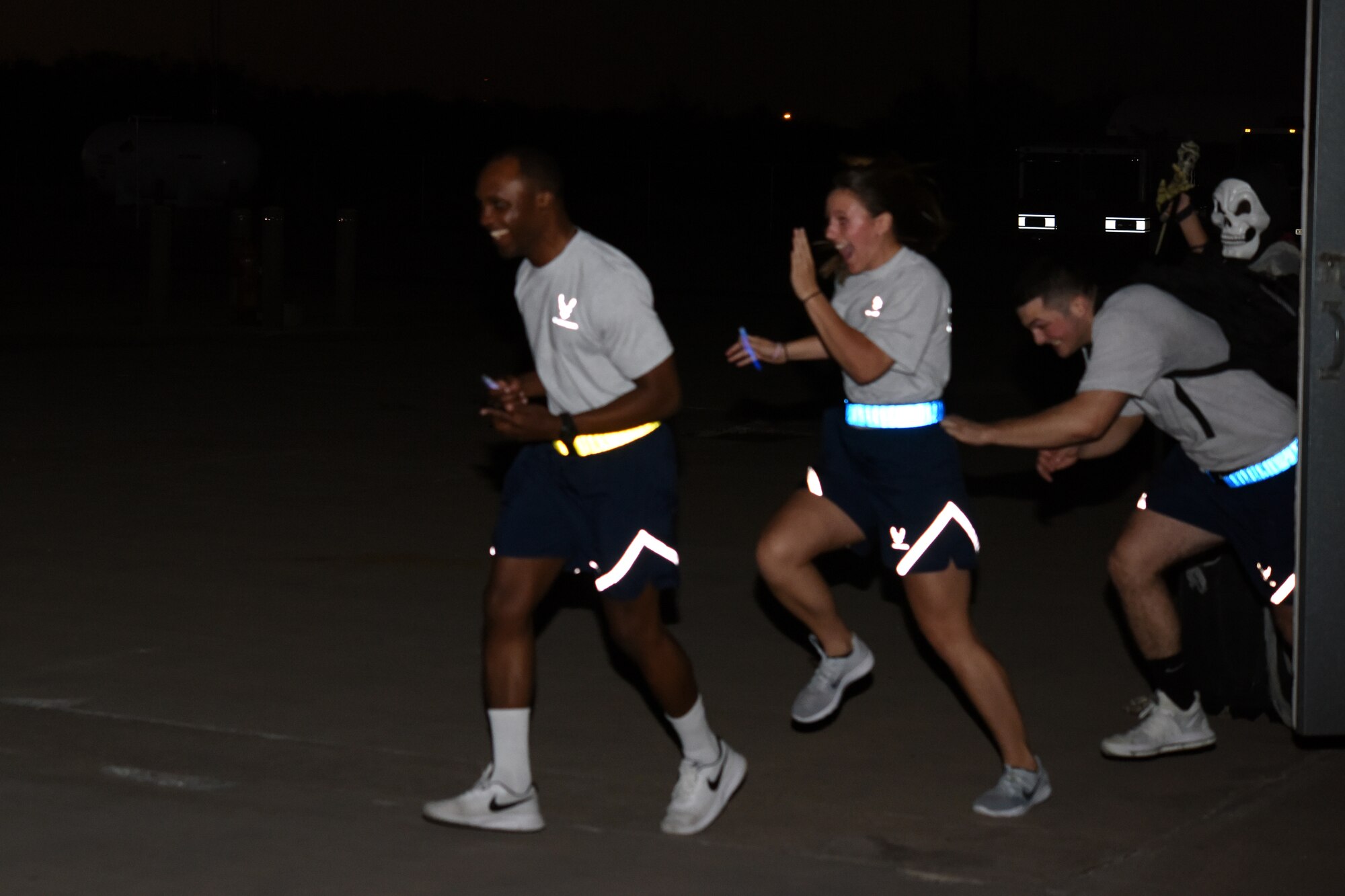 Airmen run out of the haunted house during Ghoulfellow in the Louis F. Garland Department of Defense Fire Academy on Goodfellow Air Force Base, Texas, Oct. 27, 2018. The High Bay set up a fire training tower as a haunted house with rooms dedicated to clowns, zombies and other terrors. (U.S. Air Force photo by Airman 1st Class Zachary Chapman/Released)