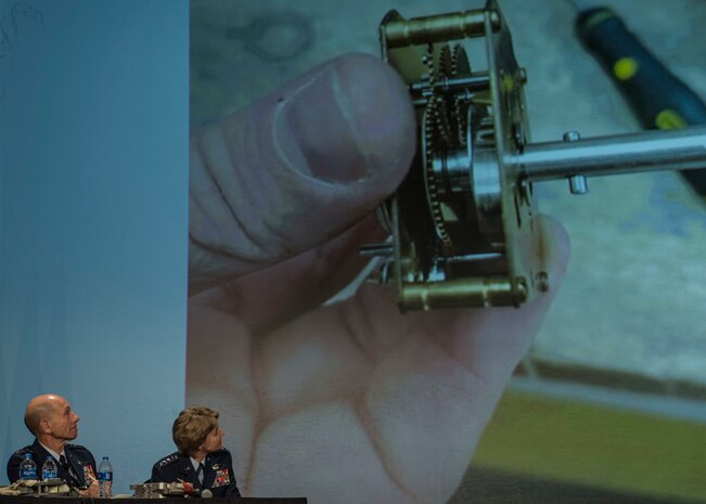 Gen. Mike Holmes, Air Combat Command commander, and Gen. Maryanne Miller, Air Mobility Command commander, observe a new design for an M-1 cargo parachute release
assembly time block fair safe presented and designed by Staff Sgt. Travis Alton from the 19th Logistical Readiness Squadron during the 2018 AMC Phoenix Spark Tank competition, where four finalists pitched their innovation ideas and creations to a panel of judges at the Airlift/Tanker Association Symposium in Grapevine, Texas, Oct. 27, 2018. "This piece has the potential to eliminate all airdrop malfunctions caused by this faulty timer," said Alton, who was later announced as the winner at the AMC level and will represent the command at the Air Force level. A/TA, AMC's premier professional development event, provides mobility Airmen an opportunity to learn about and discuss mobility priorities, issues, challenges, and successes. The venue creates dialogue between industry experts and Air Force and Department of Defense about ways to innovate, enhance mission effects and advance readiness headed into the future.  (U.S. Air Force photo by Tech. Sgt. Jodi Martinez)