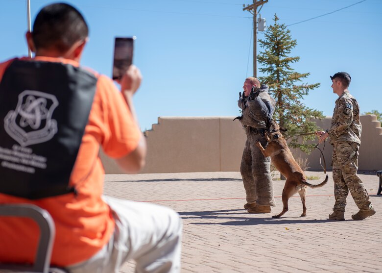 An Acoma Pueblo resident watches as members of the 377th Security Forces Squadron conduct a military working dog exhibition at U.S. Air Force Day at Acoma Pueblo, N.M., Oct. 27, 2018. (U.S. Air Force photo by Staff Sgt. J.D. Strong II)