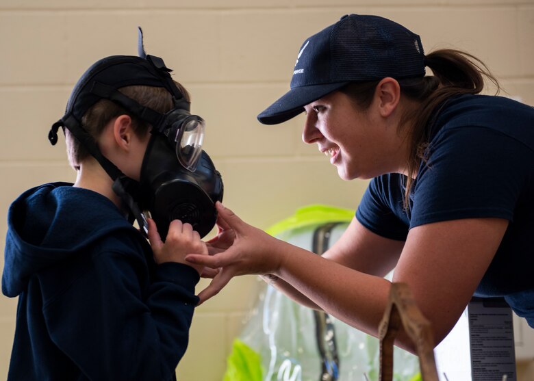 U.S. Air Force Airman 1st Class Alicia Watson, 377th Aeromedical Squadron bio-environmental technician, adjusts the gas mask on a patron of U.S. Air Force Day at Acoma Pueblo, N.M., Oct. 27. (U.S. Air Force photo by Staff Sgt. J.D. Strong II)