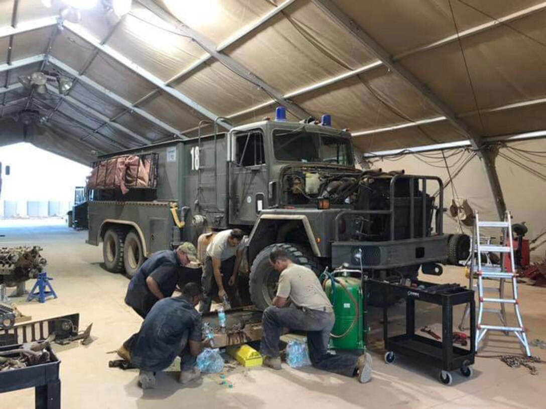 Vehicle maintainers assigned to the 724th Expeditionary Air Base Squadron work on a P-18 Combat Fire Truck radiator at Nigerien Air Base 201, Niger, Oct. 16, 2018. The maintainers were able to create a fix for the leaky radiator and return it to the fleet in three days. (Courtesy photo)