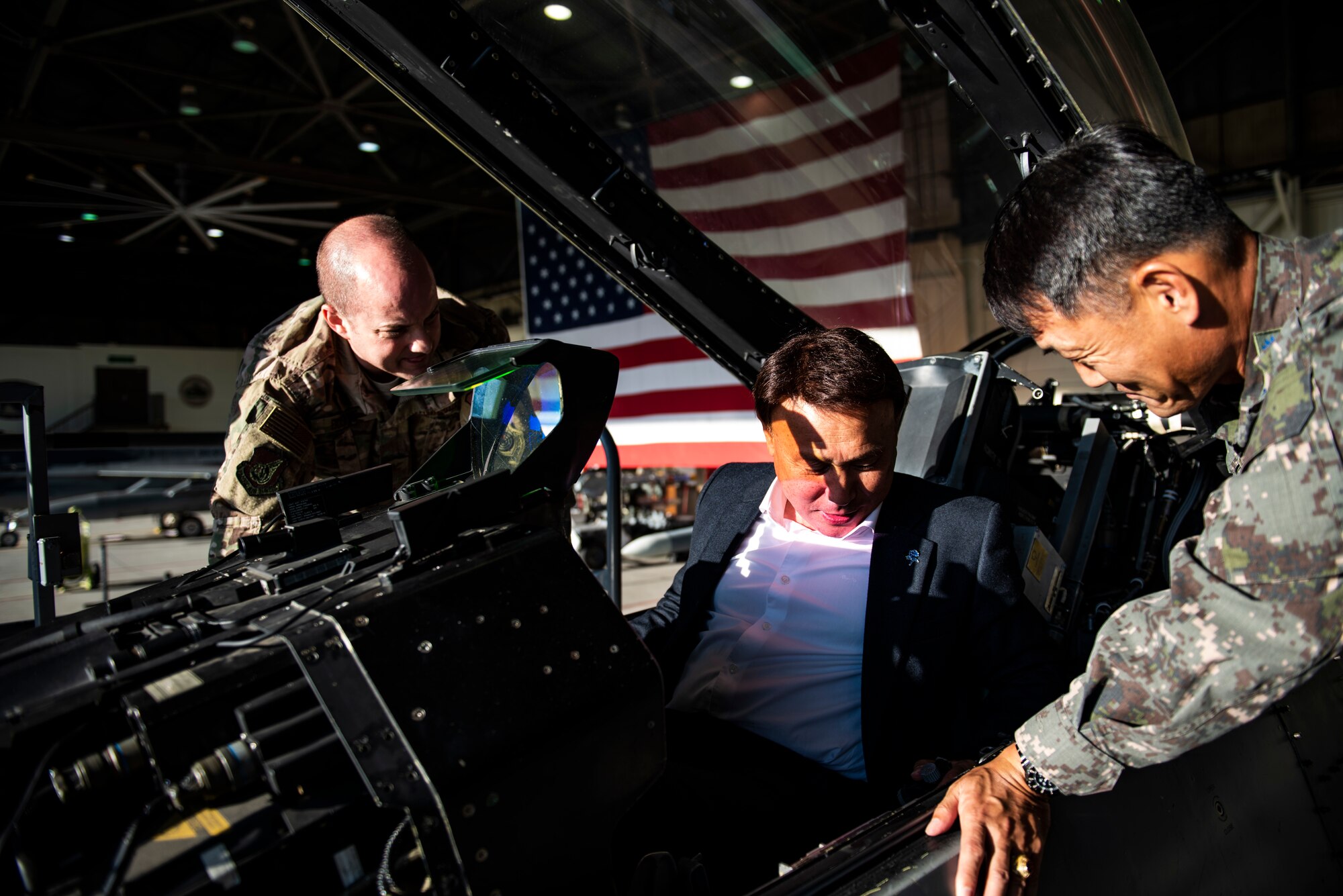 Col. John Bosone, 8th Fighter Wing commander (left) and Col. Jae-Gyun Jeon, 38th Fighter Group commander (right) seat Kang Imjune, Mayor of Gunsan (middle) in an F-16 Fighting Falcon at Kunsan Air Base, Republic of Korea. Mayor Imjune was shown the different ways Kunsan AB contributes to the overall safety and security of the Korean Peninsula with the help of Republic of Korea Air Force partners. (U.S. Air Force photo by Senior Airman Stefan Alvarez)