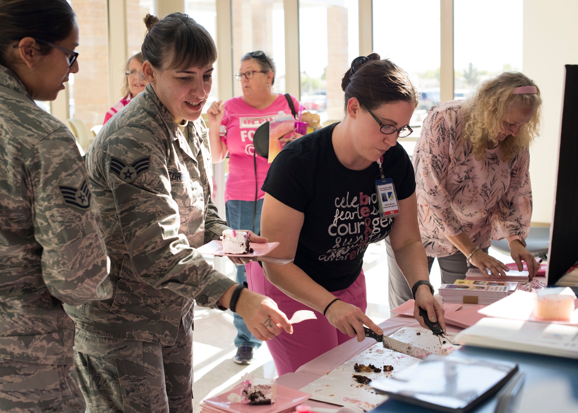 49th Medical Group staff serve cake during the 49 MDG’s Breast Cancer Awareness Month Celebration October 25, 2018, at Holloman Air Force Base, N.M. The event was organized to bring awareness to breast cancer, breast cancer risk factors, preventative measures and treatment options. (U.S. Air Force photo by Staff Sgt. BreeAnn Sachs)