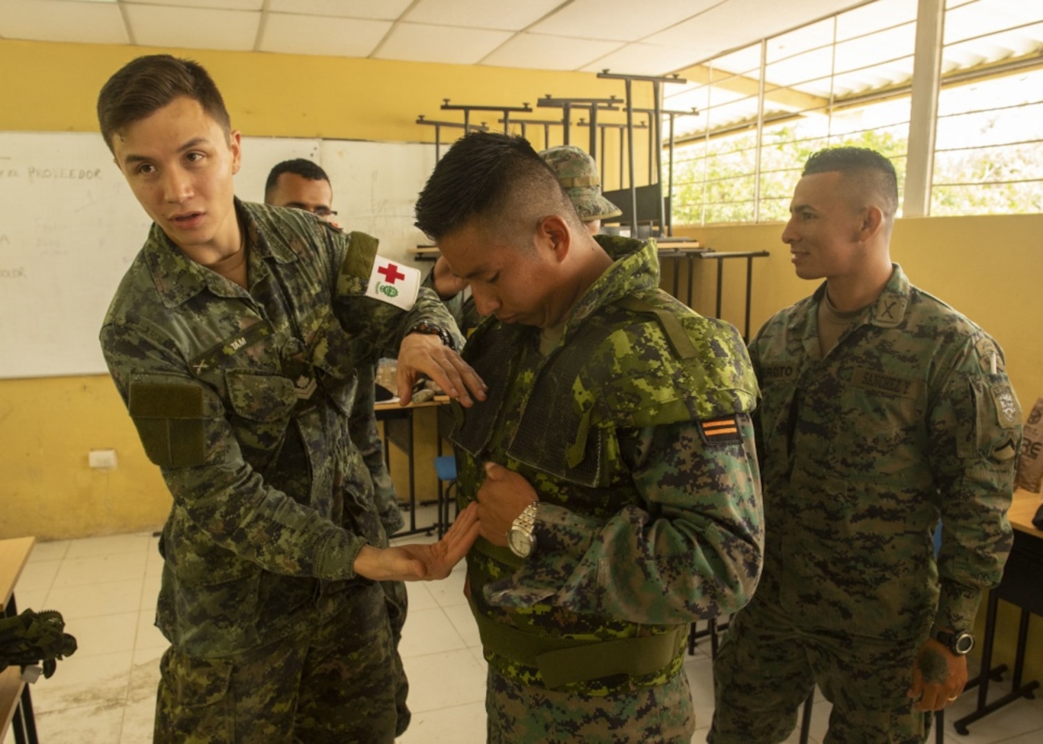 Canadian Forces Master Corporal Kristian Tam, discusses field medicine techniques during a multi-nation information exchange meeting on medicine in a tactical environment with American and Ecuadorian service members.