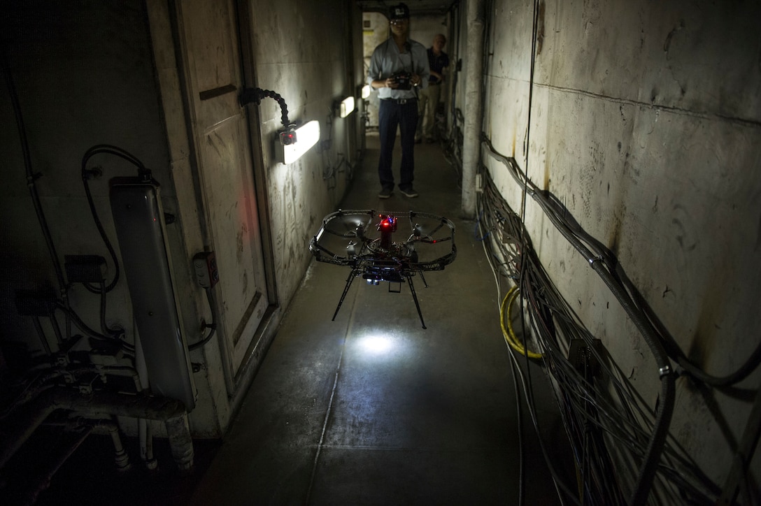 Student-researcher from Carnegie Mellon University remotely maneuvers quadrotor micro-air vehicle through narrow hallways of Naval Research
Laboratory’s ex–USS Shadwell to smoke-filled, GPS-denied area to identify fire’s location and transmit data back to research team, Mobile, Alabama,
November 5, 2014 (U.S. Navy/John F. Williams)