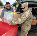 Sgt. 1st Class Lemuel E. Rodriguez (right)) from the Army Medical Department Board, helps Adam Limon from the San Antonio Food Bank unload food items donated by Army Medical Department Center & School Health Readiness Center of Excellence. In total, more than 700 pounds were donated to the San Antonio Food Bank.