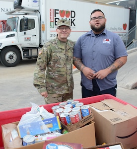 Sgt. 1st Class Lemuel E. Rodriguez (left) from the Army Medical Department Board, helps Adam Limon from the San Antonio Food Bank unload food items donated by Army Medical Department Center & School Health Readiness Center of Excellence. In total, more than 700 pounds were donated to the San Antonio Food Bank.